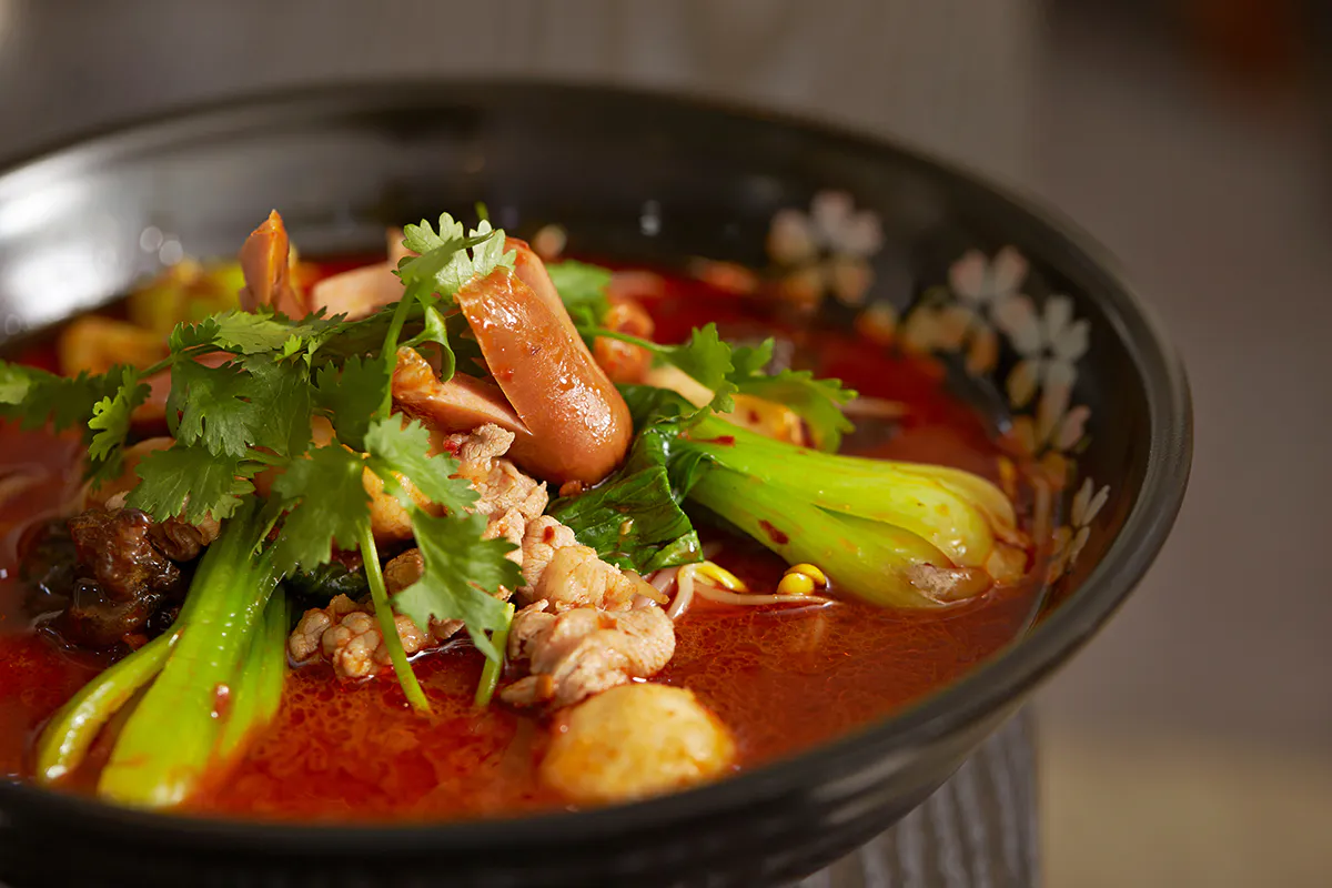 Spicy malatang soup with greens and sausage at Golden Malatang, a Malatang Restaurant in San Jose